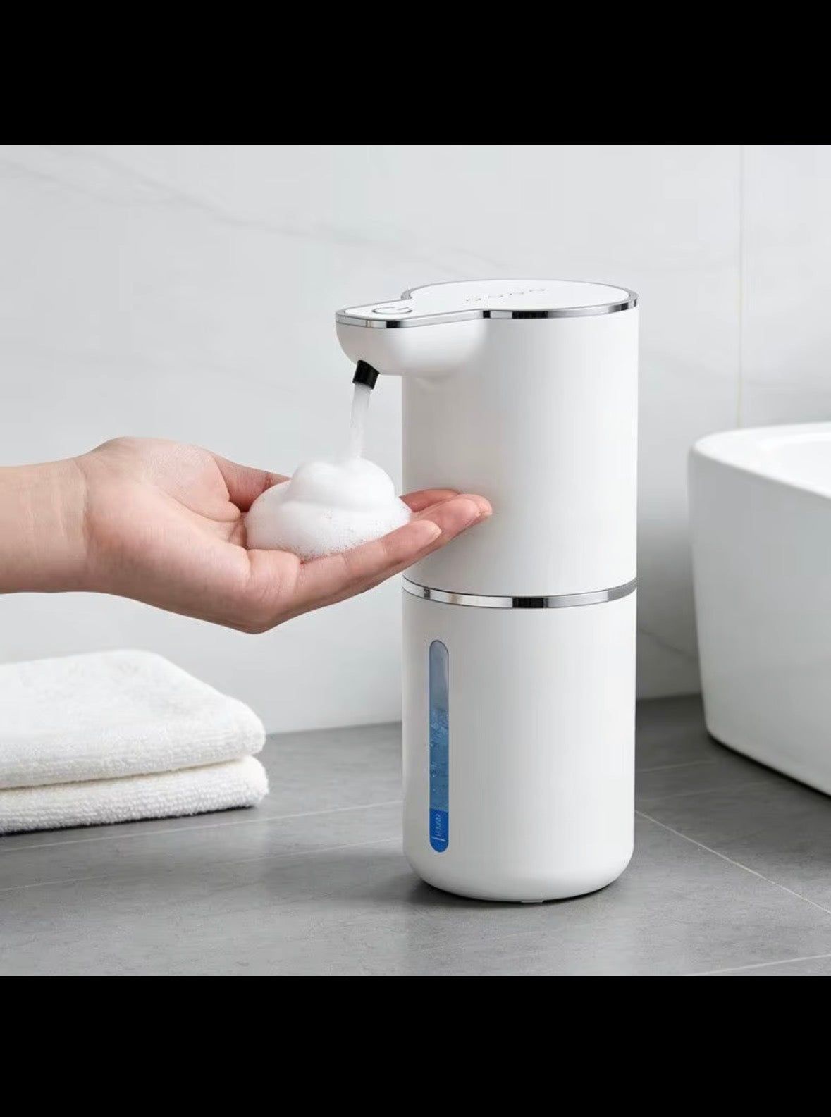 Automatic white foam soap dispenser dispensing foam into a hand